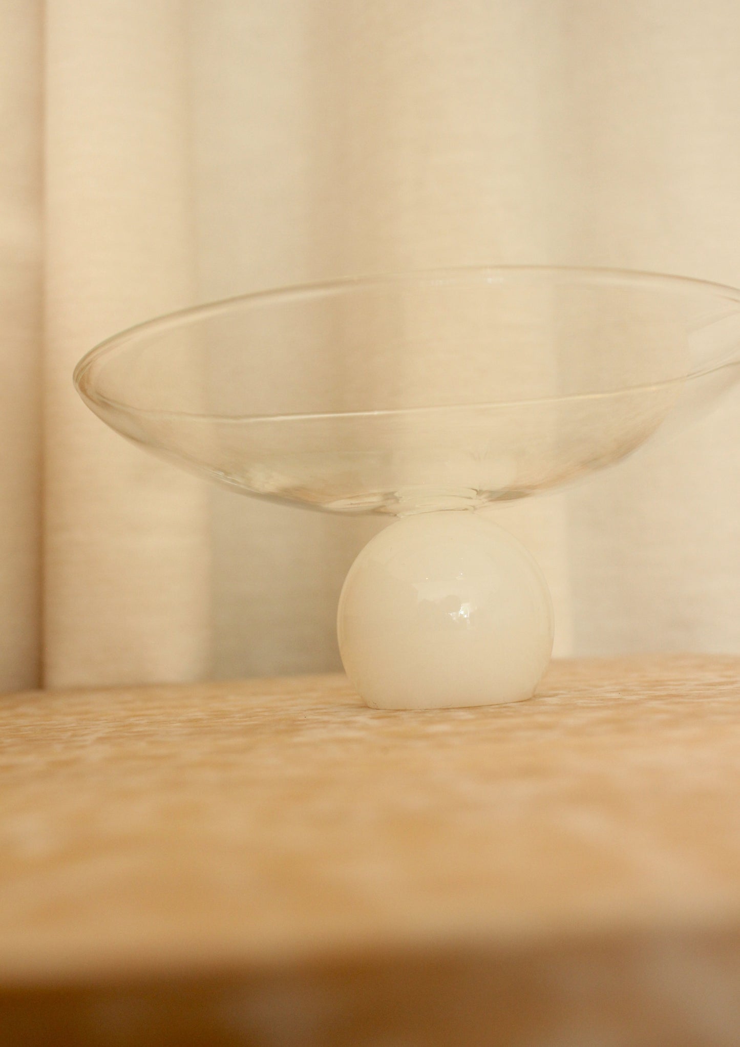 Pedestal glass bowl with clear top and white ball base.